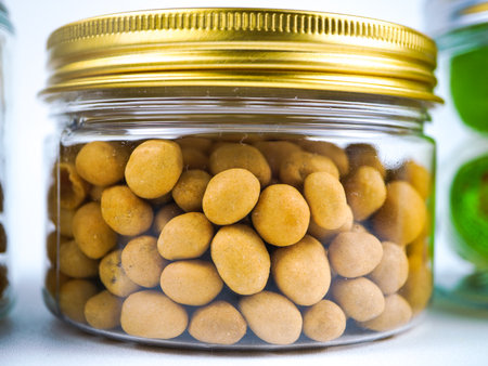 Preserved peanuts in a glass jar on a white background. Selective focus.の写真素材