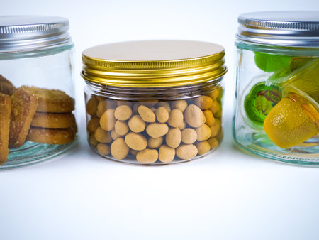 Glass jars with different kinds of cookies and biscuits on a white backgroundの写真素材