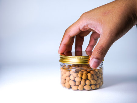 Close up of a man's hand holding a jar of soybeansの写真素材