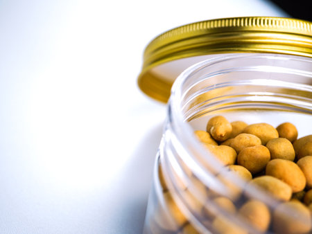 Macadamia nuts in a glass jar on a white background.の写真素材