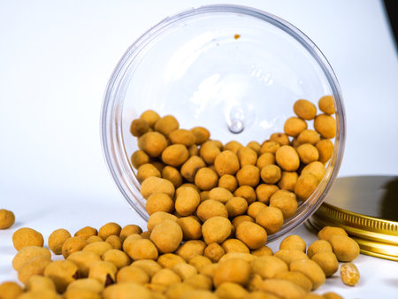 Fried peanuts in a glass jar on a white background close upの写真素材