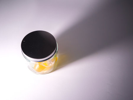 A close up shot of a jar on a white background with a shadow