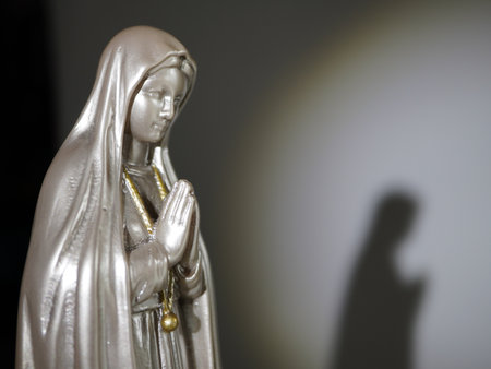 Blessed Virgin Mary with baby Jesus in her arms, lit by sunlightの写真素材
