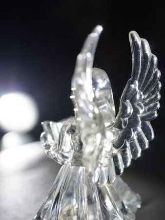 Close up of a glass angel figurine on a black background.の写真素材