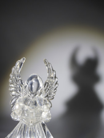 Angel figurine on a black background with a shadowの写真素材