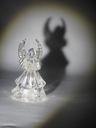 Angel figurine on a white background with a shadow on the wallの写真素材