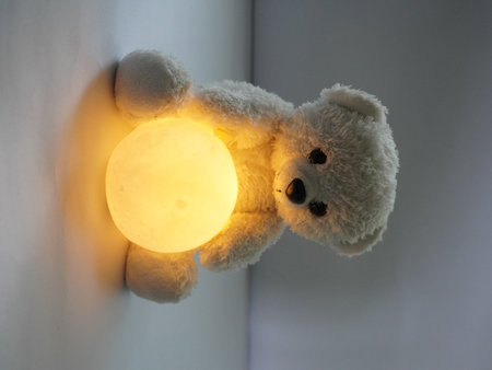 Teddy bear with moon on the wall, soft focus background.の写真素材