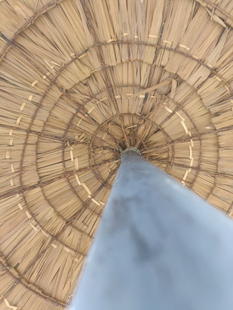 Detail of a straw umbrella made of bamboo in the park.