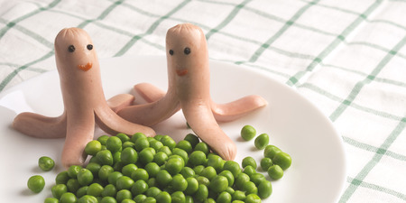 Menu for children. frankfurter with eyes and a smile. Octopus frankfurter with green peas.の写真素材
