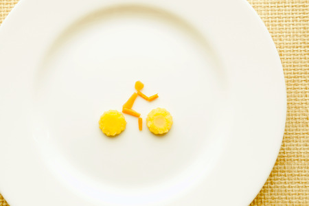 Cyclist from carrots and corn on the white plateの写真素材