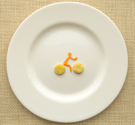 Bike of carrot and of corn on a white plateの写真素材