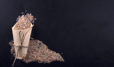 Himalayan salt with spices in a paper bag on a black background.の写真素材