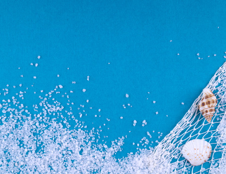 Sea salt with shells on a blue background.