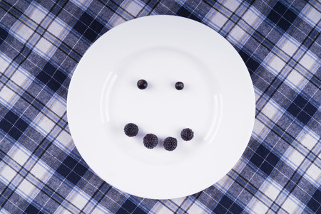 Smile of berries on a white plateの写真素材