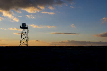 Military surveillance tower silhouette at sunsetの写真素材