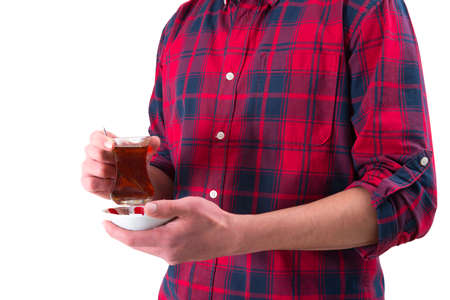 Man in red shirt is holding Turkish tea glass in his handの写真素材
