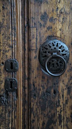Antique wooden door close-up and rusty iron knockerの写真素材