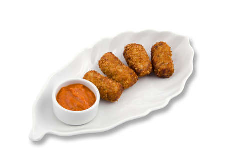 Potato croquettes and sauce on a white serving plateの写真素材