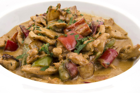 curry sauce on the plate of chicken with vegetables on a white backgroundの写真素材