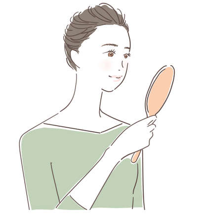 Smiling woman looking in the mirrorの写真素材
