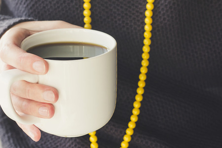 Hand holding a cup of coffee selective focusの写真素材