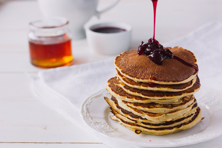 Pancakes with cherry jam on white dish selective focusの写真素材