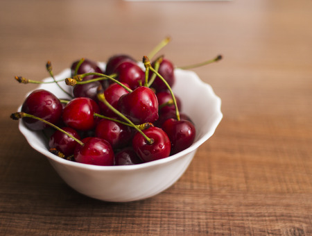 an image of Cherries on wooden table with water drops macro backgroundの写真素材