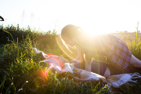 an image of Happy young mother with her daughter resting on the lake in summer dayの写真素材
