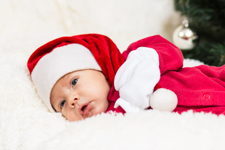 The image of a cute baby sleeping in Christmas clothesの写真素材