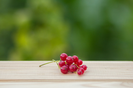 an image of red currants on a wooden tableの写真素材
