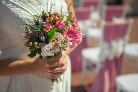 Bride holding small wedding bouquet in handsの写真素材
