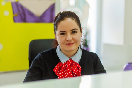 Beautiful smiling woman sitting on the reception in beauty salon.の写真素材