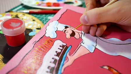 Artist paints a colorful painting. Closeup of painting process.の写真素材