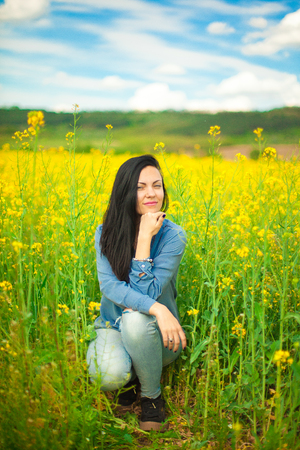 Portrait of young beautiful woman in rapeseed fieldの写真素材