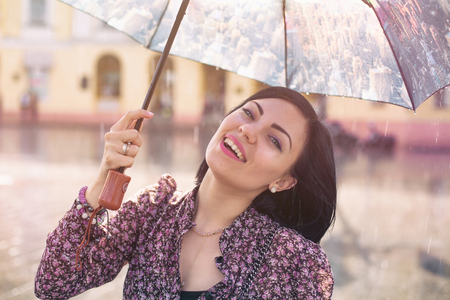 Portrait of beautiful woman under umbrella in the rainの写真素材