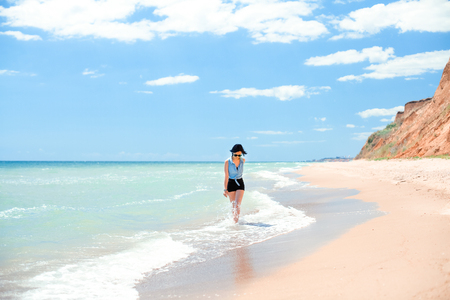 Vacation concept. Woman walking by the beach.の写真素材