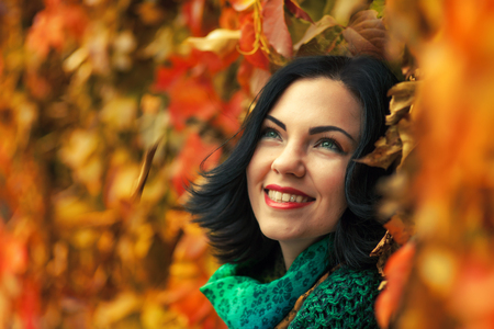 Portrait of beautiful brunette woman in autumn parkの写真素材