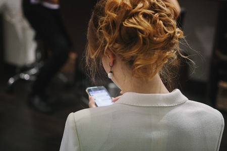 Blonde woman using her smartphone on the partyの写真素材