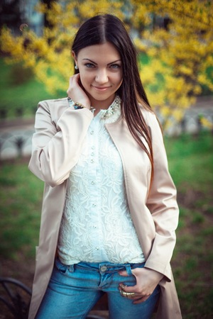 Portrait of young beautiful trendy woman standing on nature background and smilingの写真素材