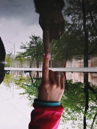 Reflection of a hand in a puddle. After the rain. Image upside down, surrealismの写真素材