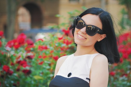 Beautiful young woman on a background of red flowers. The concept of beauty and health. Beautiful fashion girl, sweet and sensual.の写真素材