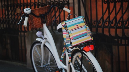 Beautiful stripes backpack on retro white bicycle in the street. Trendy hipster background.の写真素材