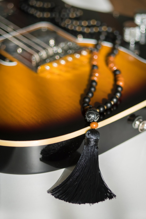 Beautiful handmade mala gems beads with tassel for mantras and meditation. Guitar background.