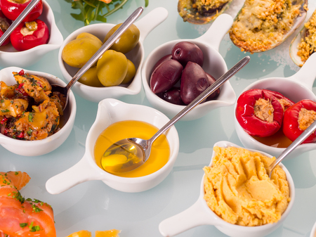 Snack set. Oktoberfest food frame concept. Variety of humus, olives, vegetables, cheese and sauces on white background. Top viewの写真素材