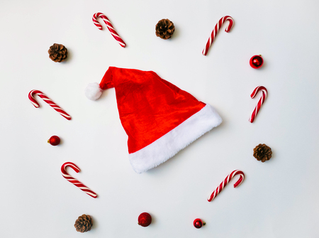 Joyful christmas background. Beautiful traditional candy cane lollipops, Santa hat. Preparing for winter holidays concept, top viewの写真素材