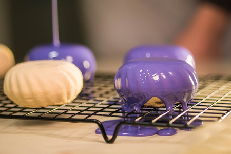 The purple icing on the cakes. Modern French mousse desserts with mirror glaze. Picture for a menu...