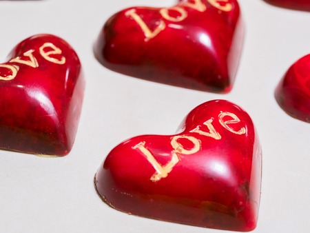 Set of colorful luxury handmade heart shaped bonbons on white background. Exclusive handcrafted chocolate candies. Product concept for chocolatierの写真素材