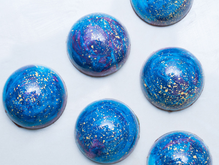 Set of colorful luxury handmade space bonbons on white background. Exclusive handcrafted chocolate candies. Product concept for chocolatierの写真素材