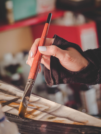 Female artists hand holding big brush. Woman painting picture.の写真素材