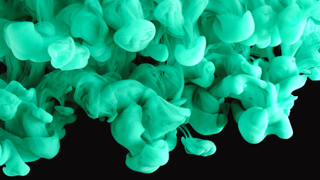 Ink in water. Colour turquoise paint reacting in water creating abstract cloud formations.の写真素材